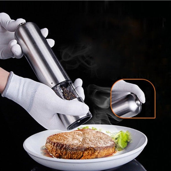 Electric Salt and Pepper Grinder being used one handed over a plate